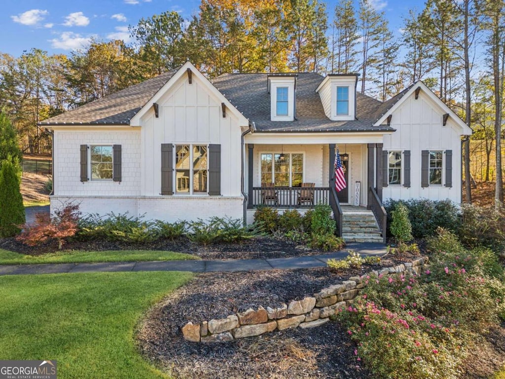 view of front of property featuring covered porch and a front yard