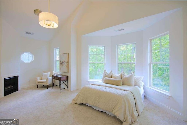 carpeted bedroom featuring high vaulted ceiling