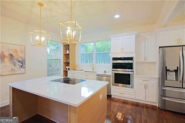 kitchen featuring white cabinets, a kitchen island, hanging light fixtures, and appliances with stainless steel finishes