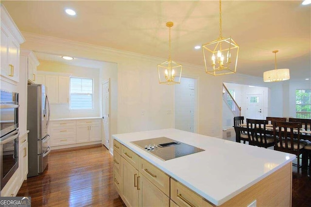 kitchen featuring a center island, white cabinets, dark hardwood / wood-style floors, appliances with stainless steel finishes, and decorative light fixtures