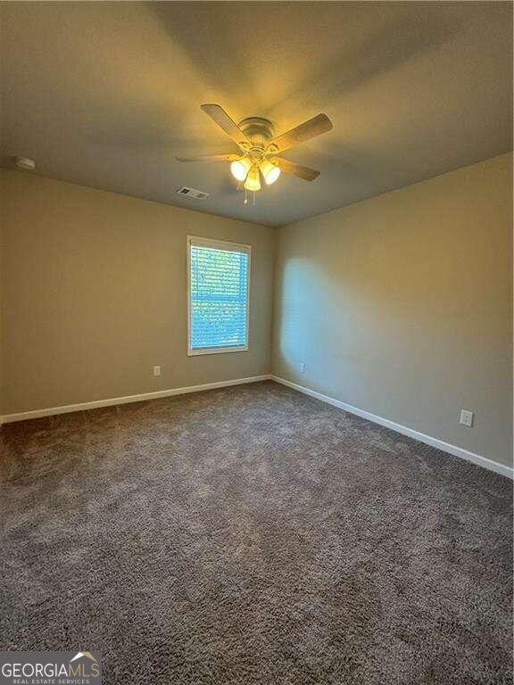 carpeted spare room with ceiling fan