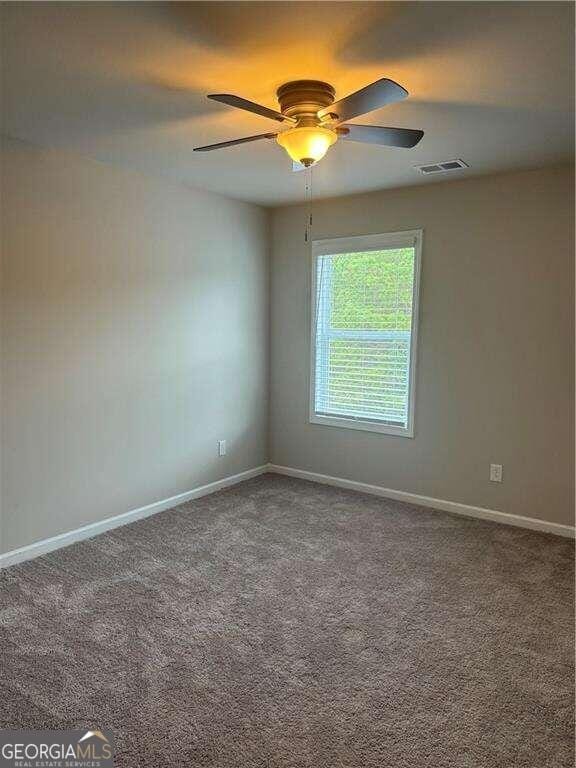 carpeted empty room featuring ceiling fan