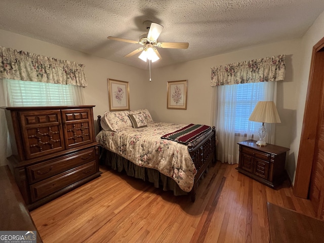 bedroom featuring a textured ceiling, ceiling fan, and hardwood / wood-style flooring