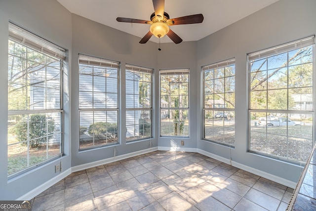 unfurnished sunroom featuring ceiling fan