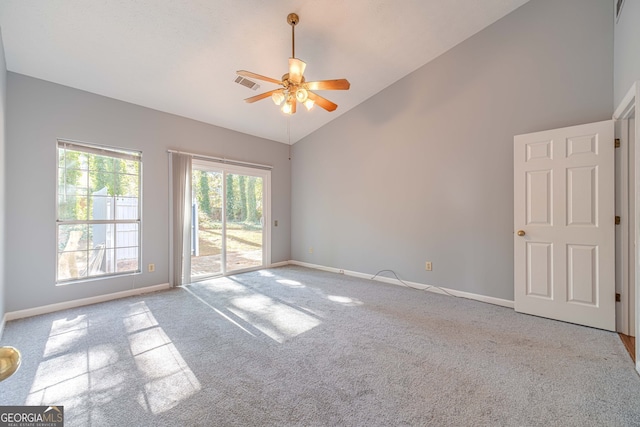 carpeted empty room with high vaulted ceiling and ceiling fan