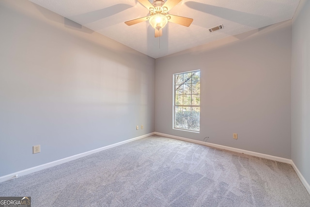 carpeted spare room featuring ceiling fan