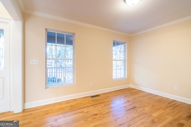 empty room with light hardwood / wood-style floors and ornamental molding