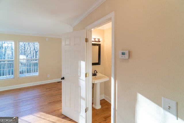 hallway featuring light wood-type flooring and crown molding