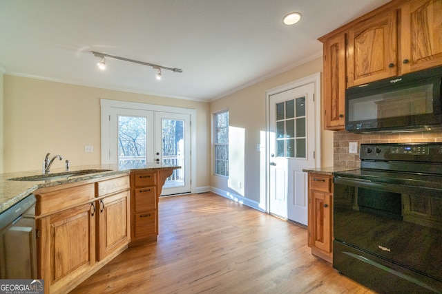 kitchen with light wood-type flooring, light stone counters, crown molding, sink, and black appliances