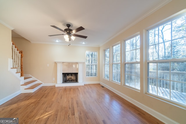 unfurnished living room featuring light wood-type flooring, ceiling fan, and ornamental molding