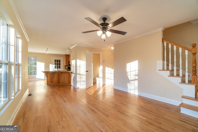 unfurnished living room featuring light wood-type flooring, ceiling fan, and crown molding