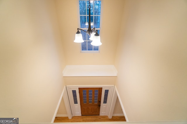 foyer entrance with light hardwood / wood-style floors and a chandelier