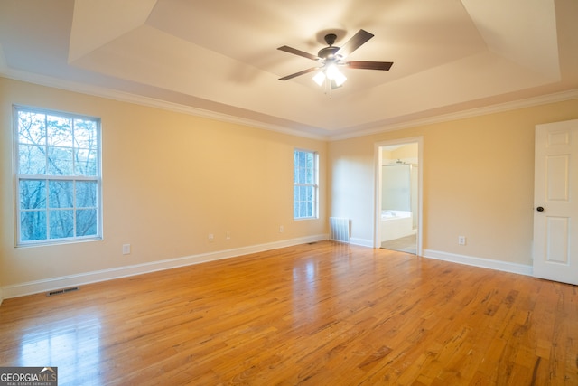 unfurnished room featuring ceiling fan, light wood-type flooring, crown molding, and a tray ceiling