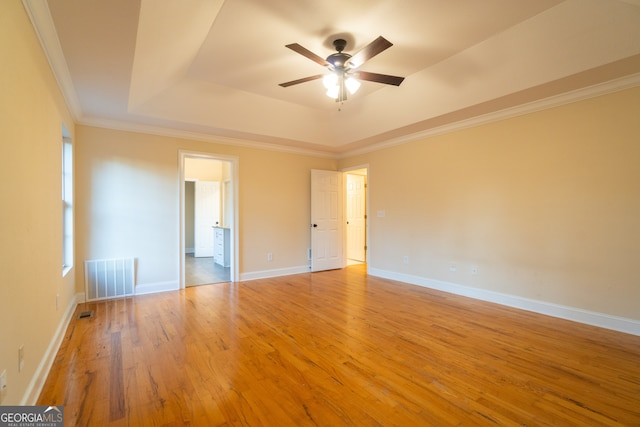 unfurnished room with a raised ceiling, ceiling fan, light hardwood / wood-style flooring, and ornamental molding