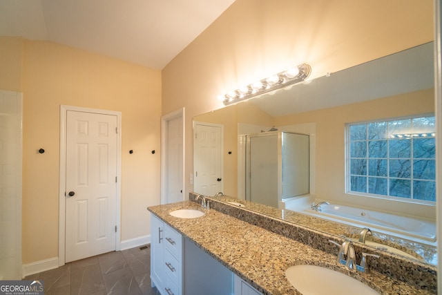 bathroom with vanity, shower with separate bathtub, and vaulted ceiling