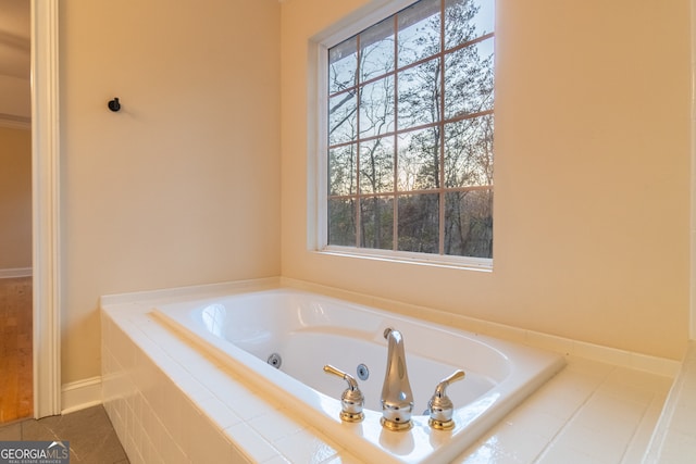 bathroom with tile patterned floors and a relaxing tiled tub