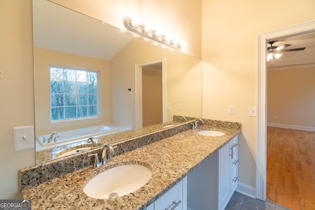 bathroom with a bathtub, vanity, vaulted ceiling, ceiling fan, and hardwood / wood-style flooring