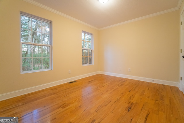 empty room featuring light hardwood / wood-style floors and crown molding