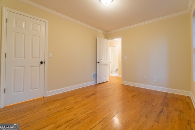 empty room featuring light hardwood / wood-style floors and ornamental molding