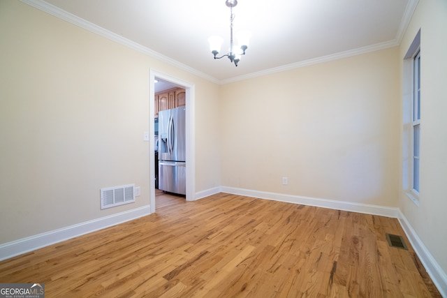 unfurnished room featuring crown molding, a chandelier, and light wood-type flooring