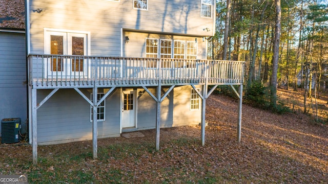 back of house with central air condition unit and a wooden deck