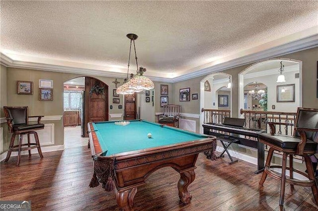 playroom with dark hardwood / wood-style flooring, ornamental molding, a textured ceiling, and pool table