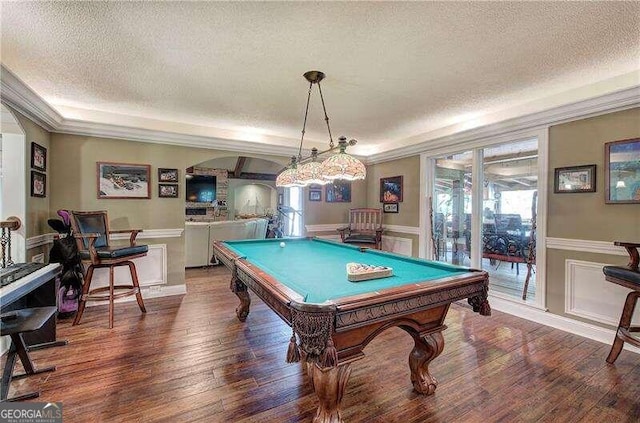 game room with a textured ceiling, dark hardwood / wood-style floors, ornamental molding, and billiards