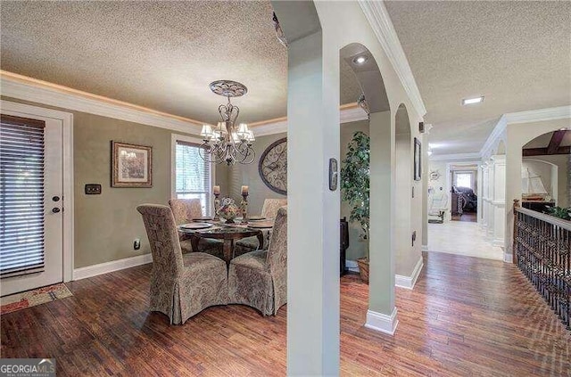 dining area featuring wood-type flooring, a textured ceiling, and crown molding