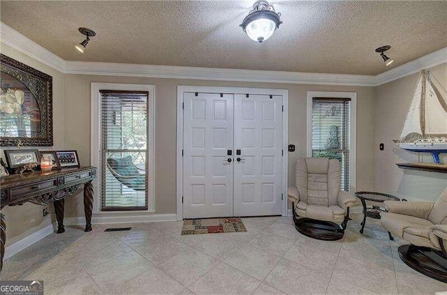 entrance foyer featuring ornamental molding, a textured ceiling, and light tile patterned floors