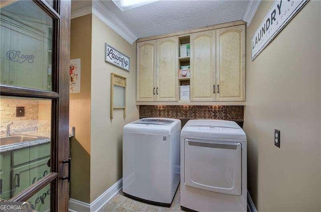 laundry room featuring cabinets, washing machine and dryer, crown molding, a textured ceiling, and light tile patterned flooring