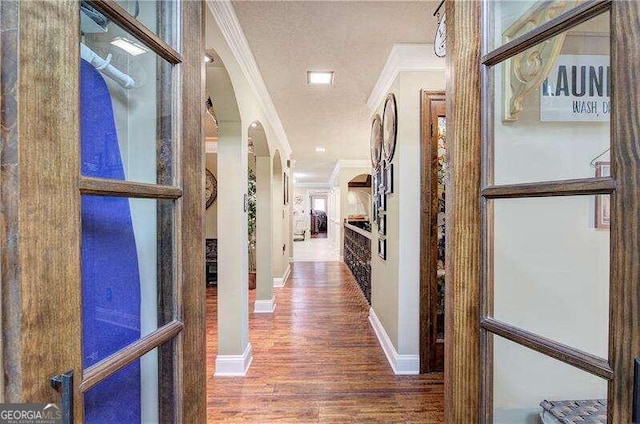 corridor featuring wood-type flooring and crown molding