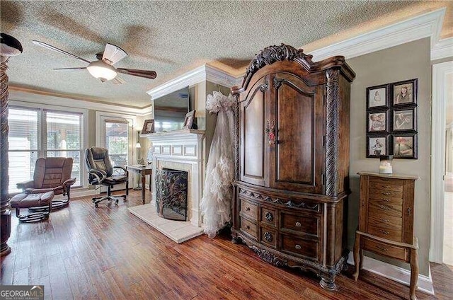 sitting room featuring hardwood / wood-style floors, a textured ceiling, and ornamental molding