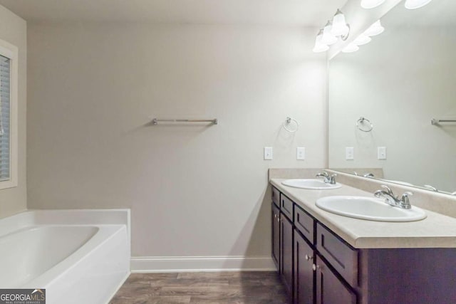 bathroom with a bathing tub, vanity, and wood-type flooring