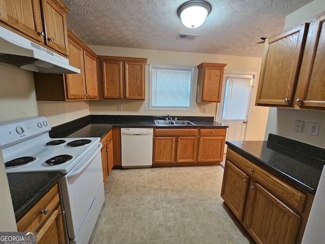 kitchen with a textured ceiling, sink, and white appliances