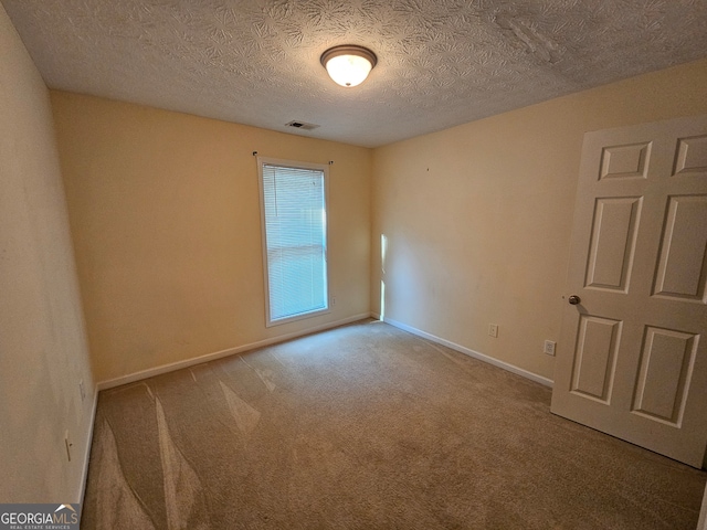 carpeted spare room featuring a textured ceiling