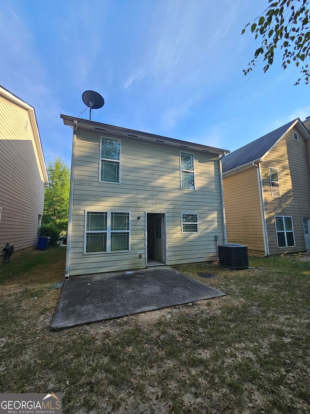 back of house featuring a lawn, central AC unit, and a patio area