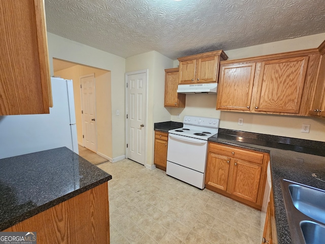 kitchen featuring a textured ceiling, white appliances, and sink