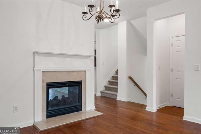 unfurnished living room featuring dark wood-type flooring and a notable chandelier