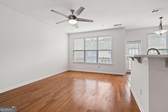 unfurnished living room with hardwood / wood-style flooring and ceiling fan