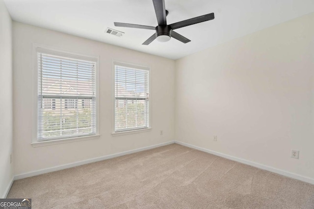 spare room featuring light carpet and ceiling fan