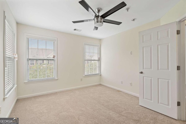 spare room with light carpet and ceiling fan