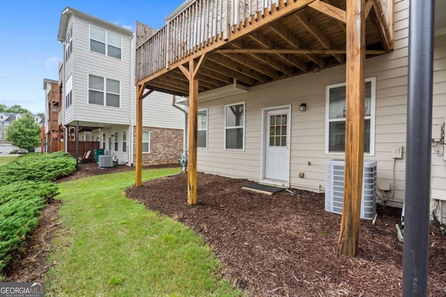 rear view of house featuring a yard, central AC, and a wooden deck