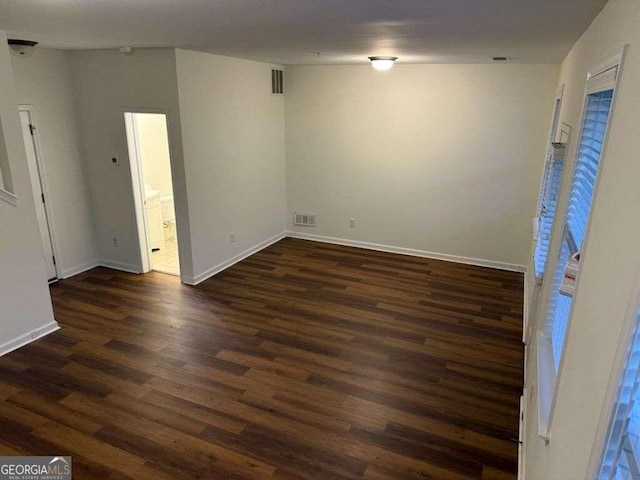 unfurnished room with dark wood-type flooring