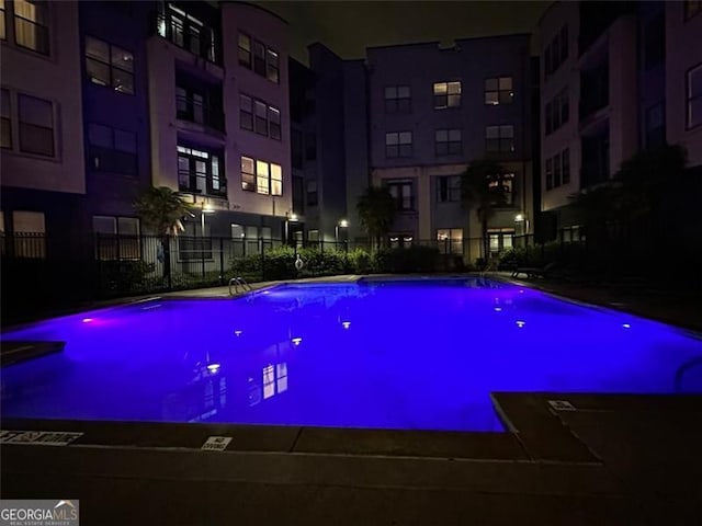 view of pool at twilight