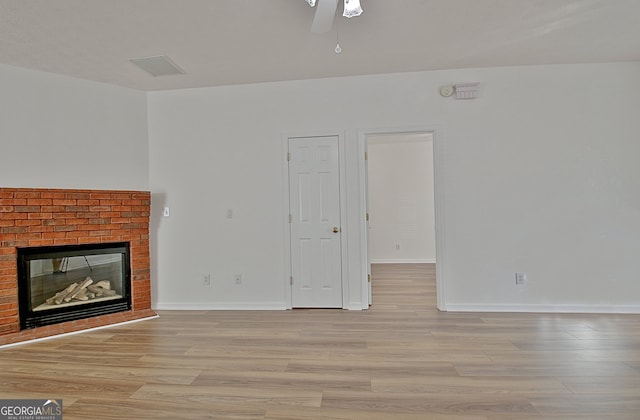 unfurnished living room featuring ceiling fan, a fireplace, and light hardwood / wood-style floors