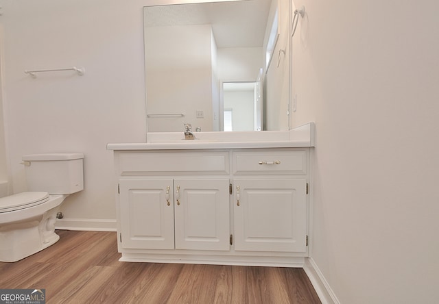 bathroom featuring hardwood / wood-style floors, vanity, and toilet