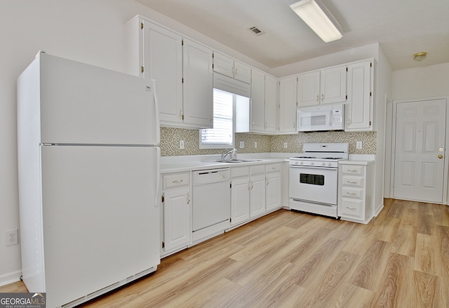 kitchen with white cabinets, light hardwood / wood-style floors, and white appliances