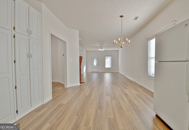 interior space with a textured ceiling, light hardwood / wood-style floors, and ceiling fan with notable chandelier