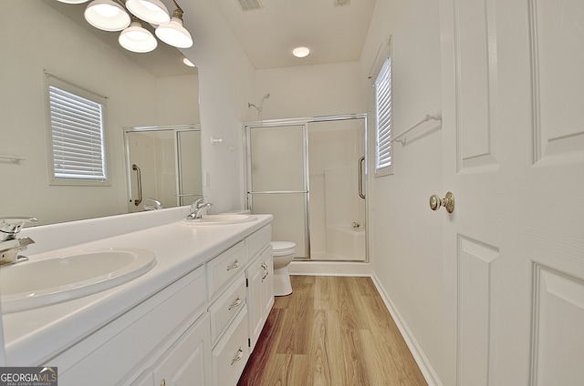 bathroom with hardwood / wood-style flooring, vanity, toilet, and walk in shower