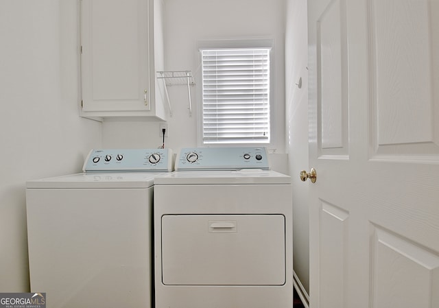 washroom with washing machine and clothes dryer and cabinets